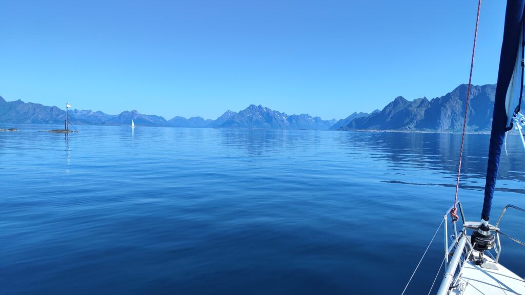 pięna błękitno granatoa woda morza norweskiego z tłem gór